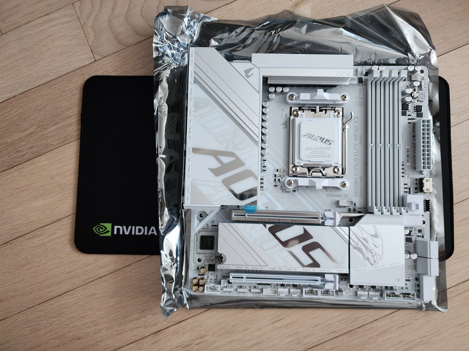 AM5 메인보드와 Ryzen 5 9600X CPU를 조립 전 책상 위에 둔 모습
